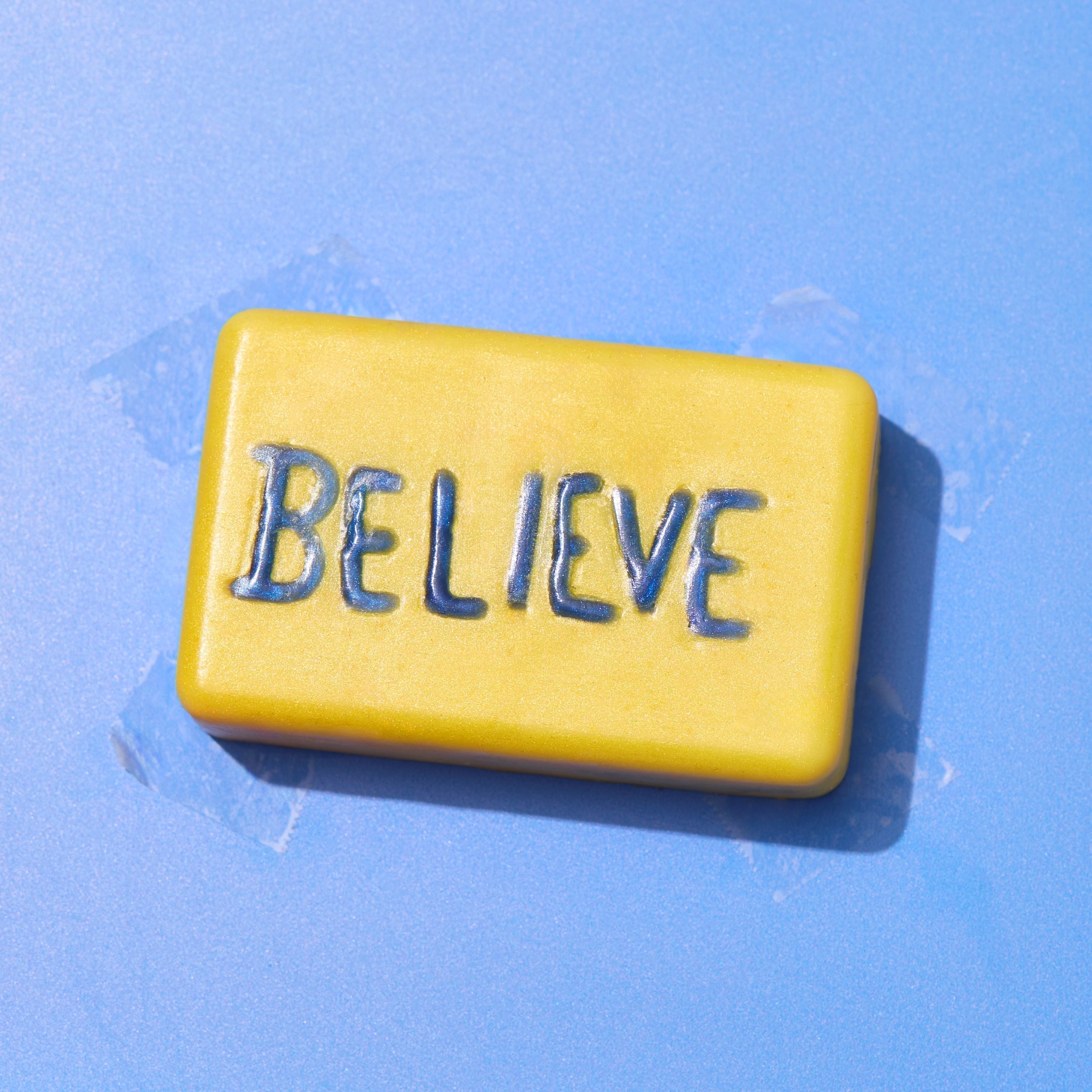 yellow bar of soap with believe in blue