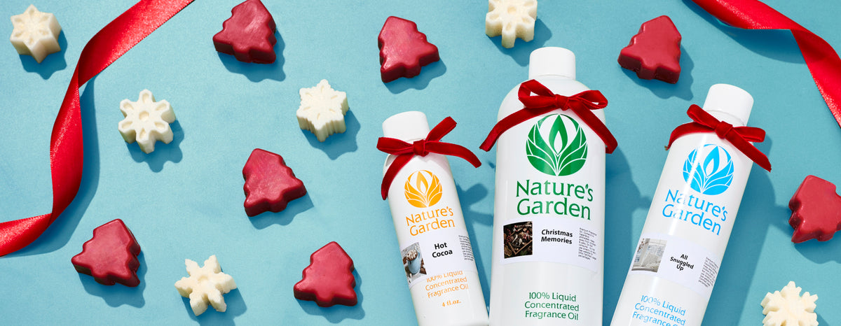 Nature’s Garden holiday fragrance oils tied with red bows, surrounded by red Christmas tree and white snowflake shapes on a blue background with curling red ribbon.