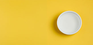 Odor eliminator base in a white bowl on a bright yellow background.