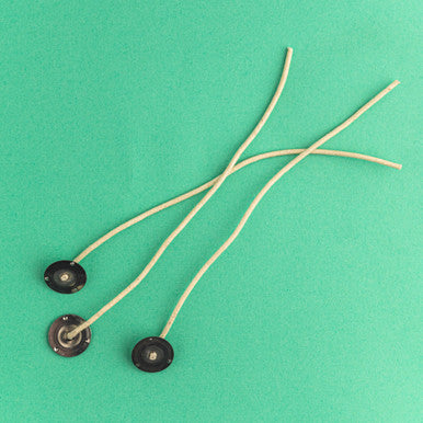Three zinc wicks on a green background