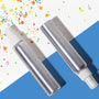 Two silver spray bottles with white nozzles on a blue and multicolored confetti background