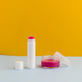 Lip balm and container on a yellow and gray background