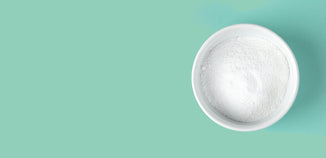 White bowl filled with fine white powder on a mint green background.