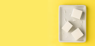 White wax blocks scattered in a rectangular tray on a yellow background.