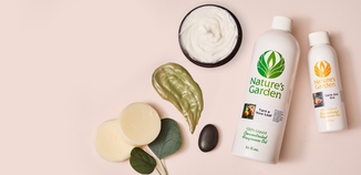 Nature’s Garden fragrance oil bottles surrounded by spa-inspired elements like cream, leaves, and smooth stones on a neutral background.