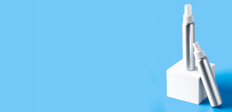 Two silver aluminum spray bottles displayed on white blocks against a bright blue background.