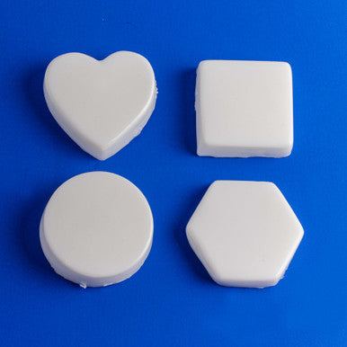 Four white foam shapes (heart, square, circle, hexagon) on a blue background