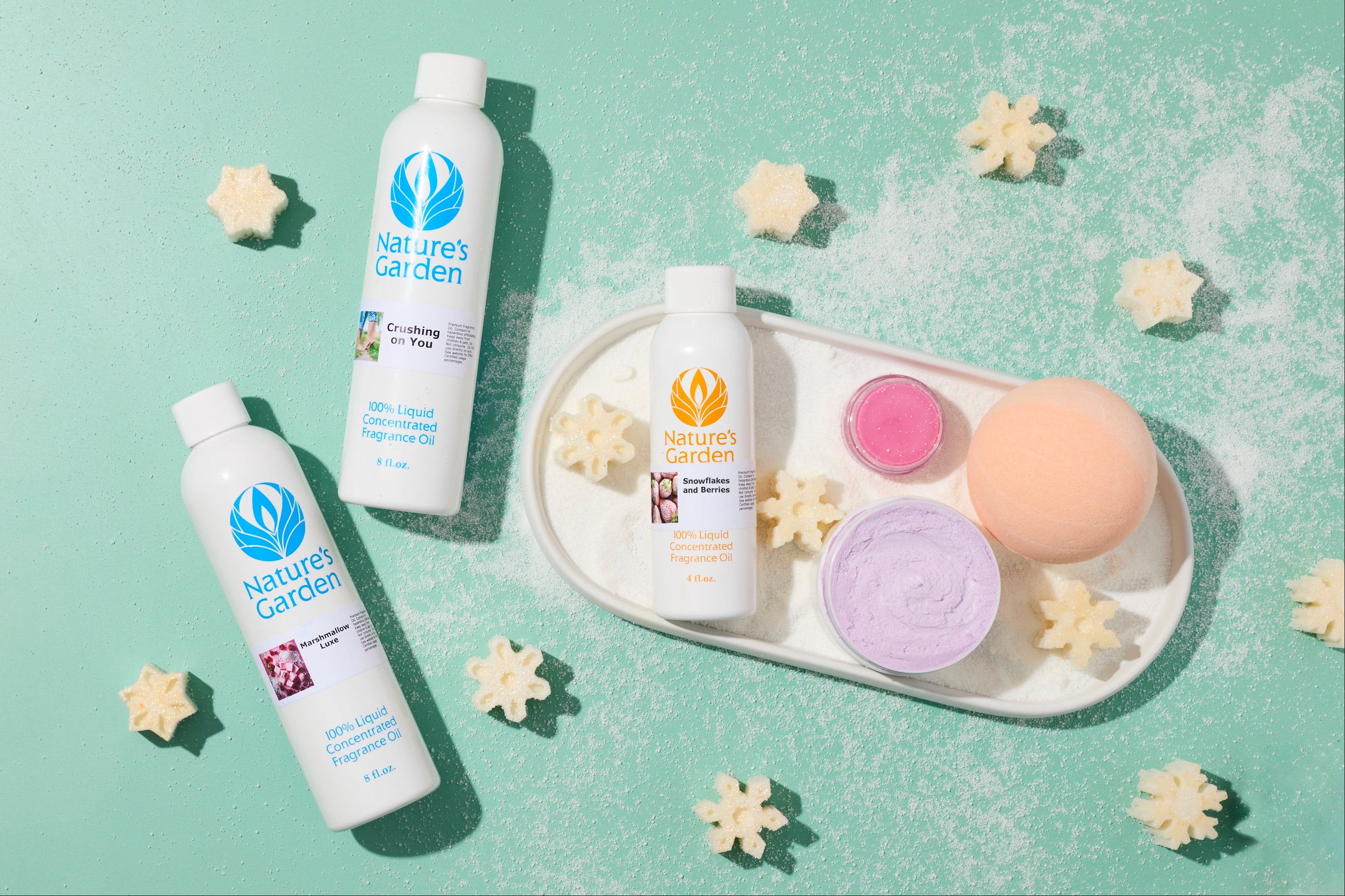 Festive snowflakes made of soap and bottles of fragrance laid on a green background.