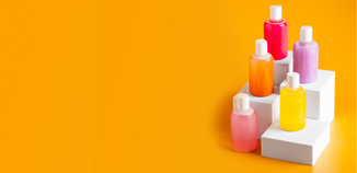Colorful Bath gels stocked on white blocks sitting on an orange background.